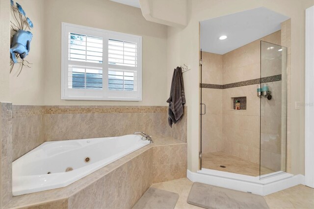 bathroom featuring a jetted tub, tile patterned flooring, and a shower stall