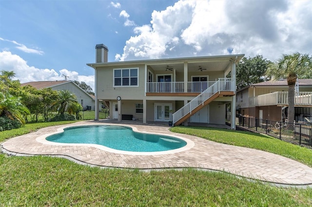 pool featuring a lawn, a patio, ceiling fan, fence, and french doors