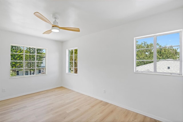 spare room featuring a healthy amount of sunlight, light hardwood / wood-style flooring, and ceiling fan