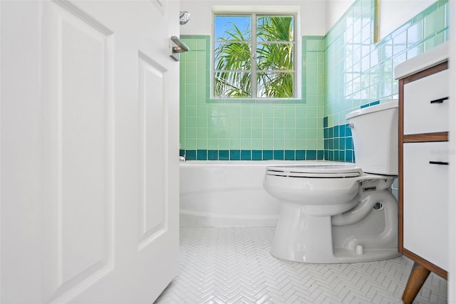 bathroom featuring a tub to relax in, toilet, and tile patterned floors