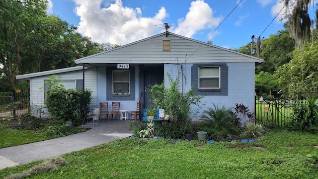 bungalow-style house with fence and a front lawn