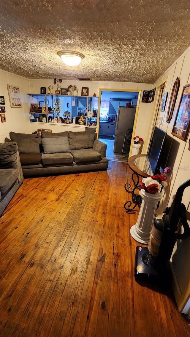 living room featuring a textured ceiling and hardwood / wood-style flooring