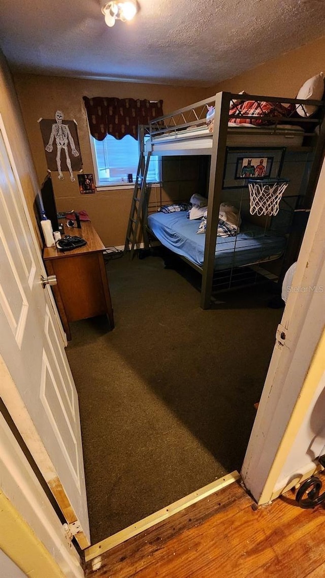 bedroom featuring a textured ceiling and wood finished floors