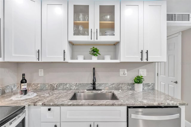 kitchen featuring stainless steel dishwasher, sink, light stone countertops, and white cabinetry