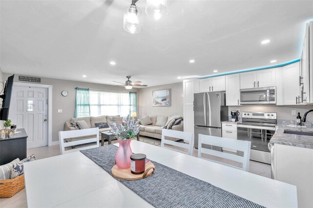 dining room with ceiling fan and sink