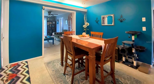 dining space featuring ceiling fan and light carpet