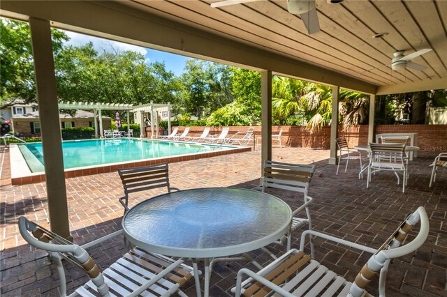 view of patio / terrace featuring a pergola, ceiling fan, and a community pool