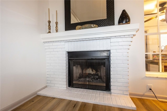 details featuring hardwood / wood-style floors and a brick fireplace