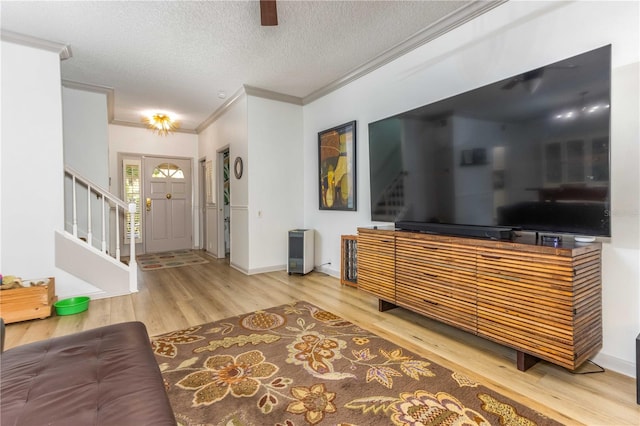 foyer entrance with crown molding, a textured ceiling, and hardwood / wood-style flooring