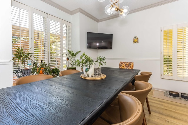 dining room with an inviting chandelier, ornamental molding, and hardwood / wood-style flooring