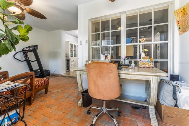 office space with built in desk, beverage cooler, and ceiling fan