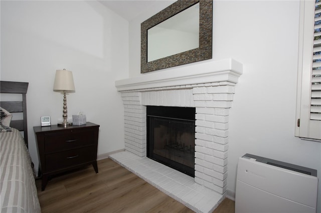 room details with wood-type flooring and a brick fireplace