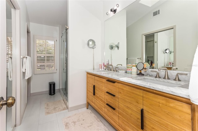 bathroom featuring vanity, lofted ceiling with skylight, tile patterned floors, and a shower with door