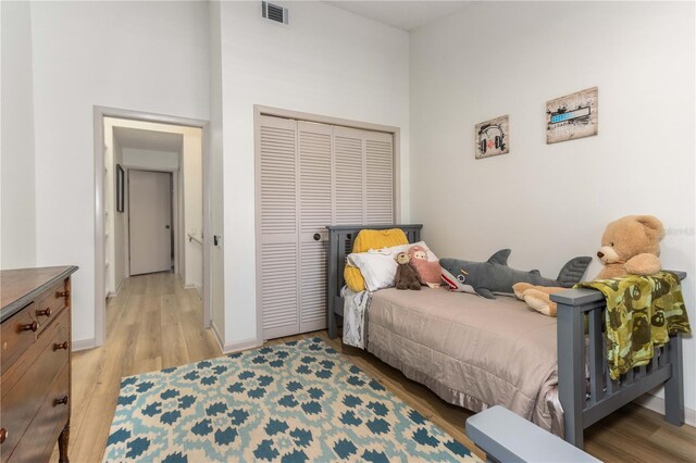 bedroom with light hardwood / wood-style floors and a closet