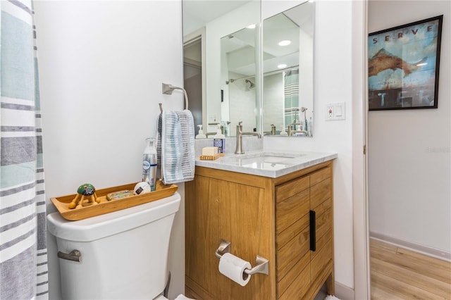 bathroom featuring toilet, hardwood / wood-style floors, and vanity