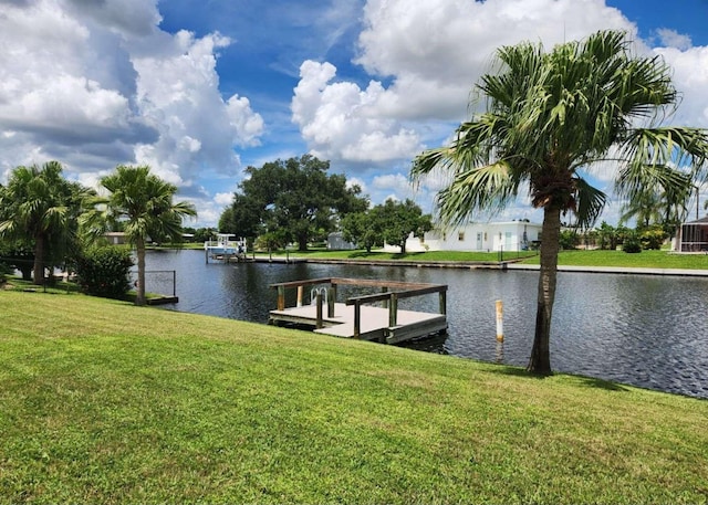 dock area with a lawn and a water view