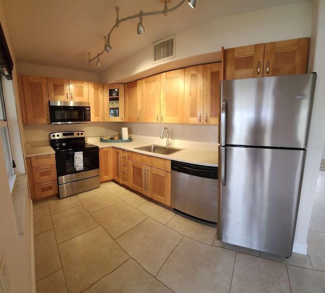 kitchen with light tile patterned floors, stainless steel appliances, and sink