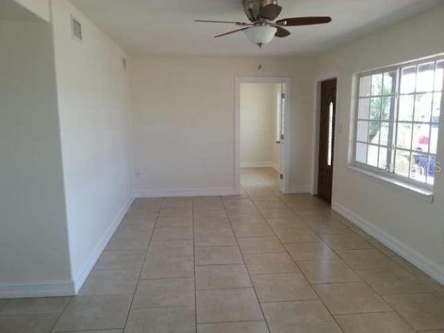 spare room featuring light tile patterned floors and ceiling fan