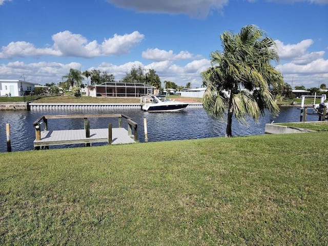 view of dock with a yard and a water view