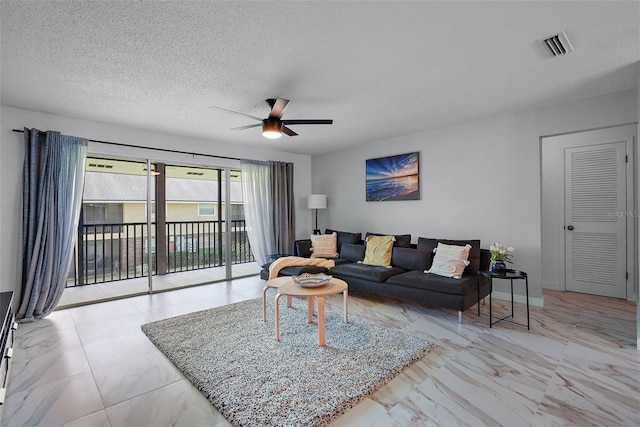 living room with a textured ceiling and ceiling fan