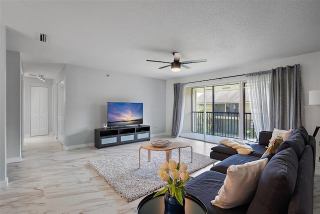 living room with a textured ceiling and ceiling fan