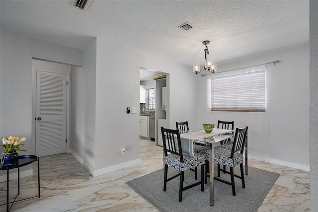 dining room featuring an inviting chandelier and a textured ceiling