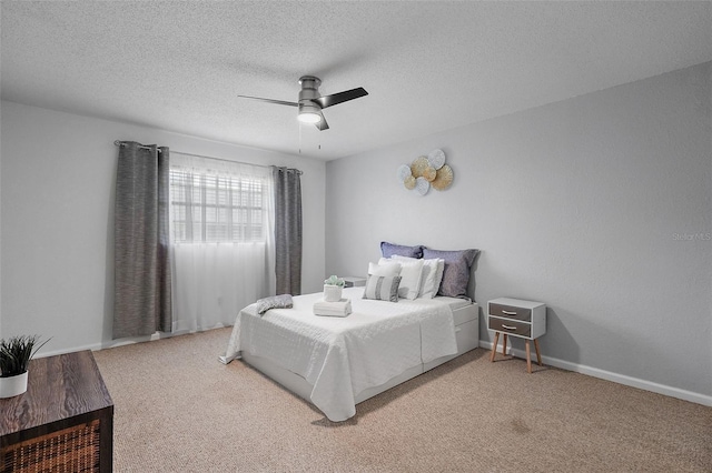 bedroom with ceiling fan, carpet, and a textured ceiling