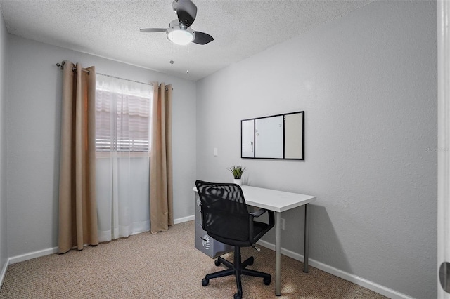 carpeted home office with a textured ceiling and ceiling fan