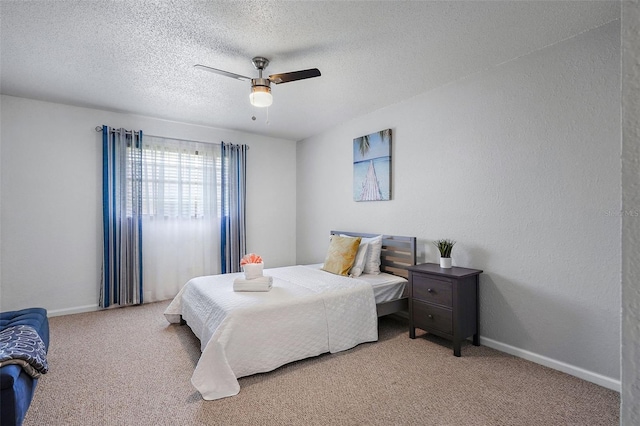 carpeted bedroom featuring ceiling fan and a textured ceiling