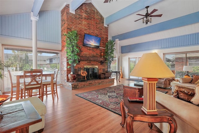 living room featuring plenty of natural light, ceiling fan, a brick fireplace, and wood-type flooring