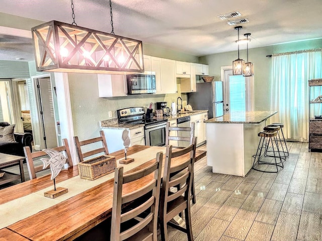 dining space with light hardwood / wood-style floors and sink