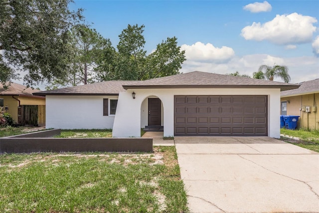 single story home featuring a garage and a front lawn