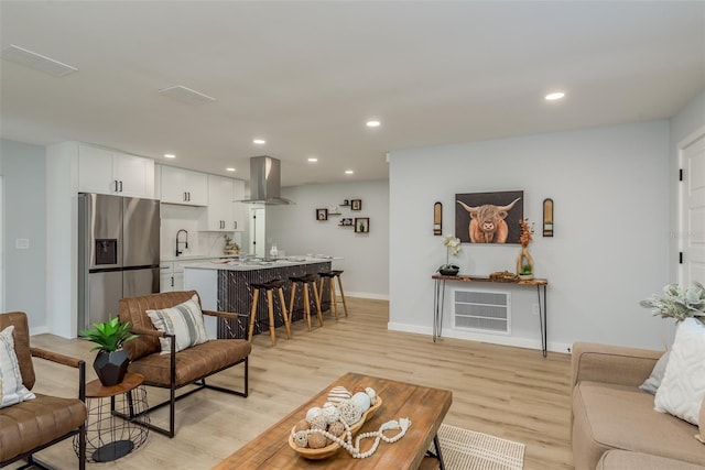 living room with light wood-type flooring and sink