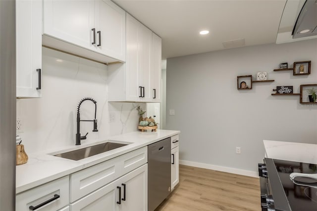 kitchen featuring dishwasher, light stone counters, sink, and light hardwood / wood-style flooring