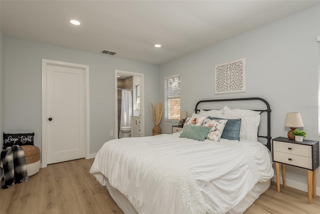 bedroom featuring light hardwood / wood-style flooring and ensuite bath