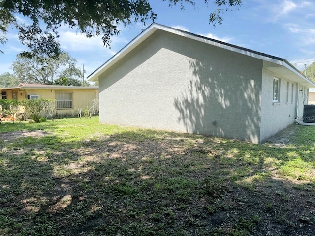 view of home's exterior with cooling unit and a yard