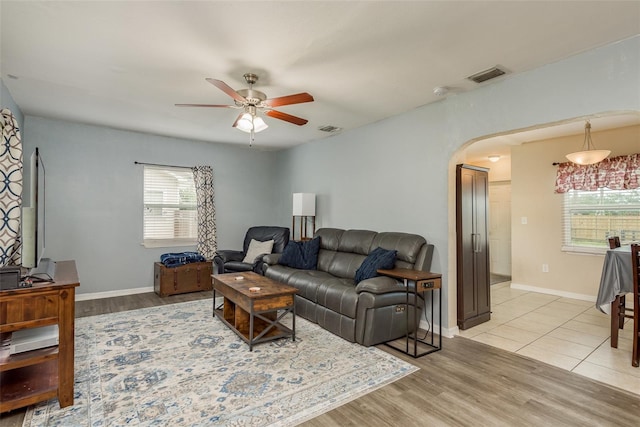 living room with light hardwood / wood-style flooring, ceiling fan, and a healthy amount of sunlight