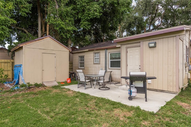 back of house with a yard, a storage unit, and a patio