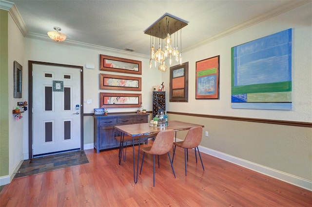 dining space with ornamental molding, dark hardwood / wood-style floors, and a chandelier