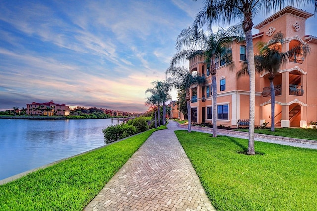 view of property's community featuring a lawn and a water view