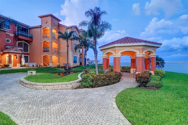 surrounding community featuring a water view and a lawn