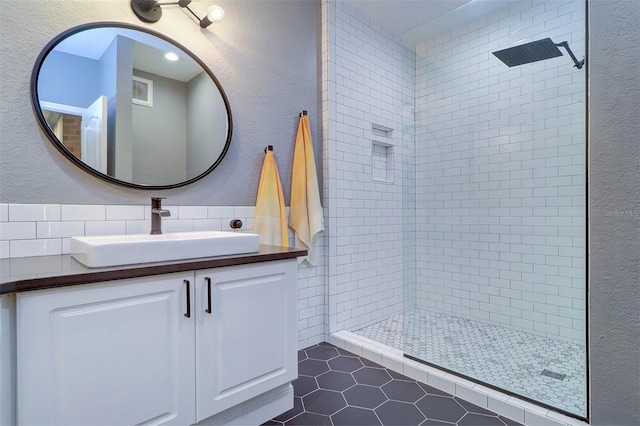 bathroom featuring vanity, tasteful backsplash, tiled shower, tile walls, and tile patterned floors