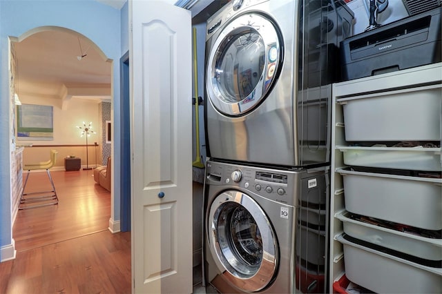 laundry area featuring stacked washer / dryer and hardwood / wood-style flooring