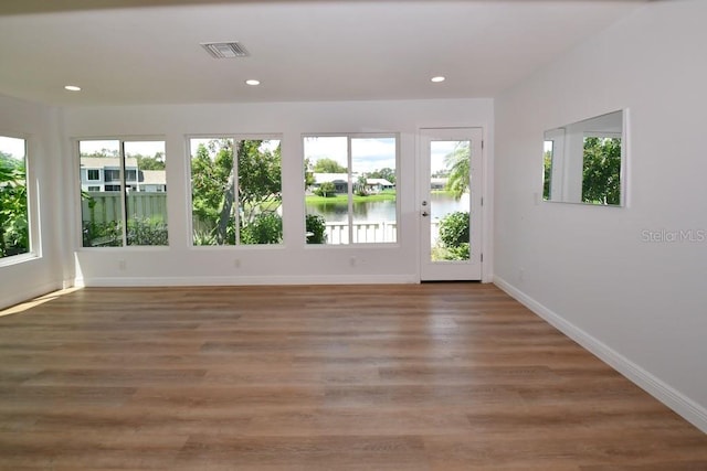 interior space featuring wood-type flooring and a water view