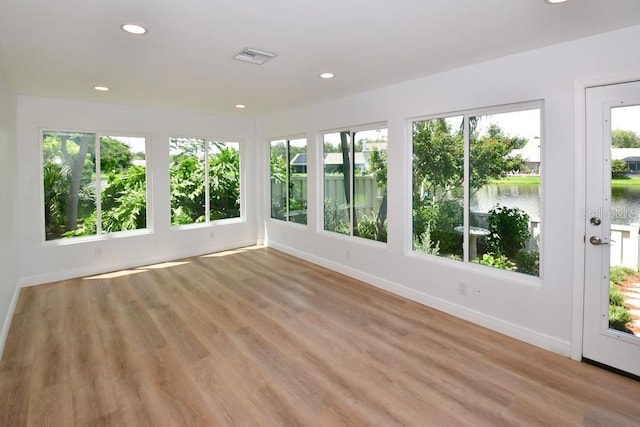 unfurnished sunroom with a healthy amount of sunlight and a water view