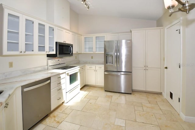 kitchen featuring white cabinets, stone tile floors, appliances with stainless steel finishes, and glass insert cabinets