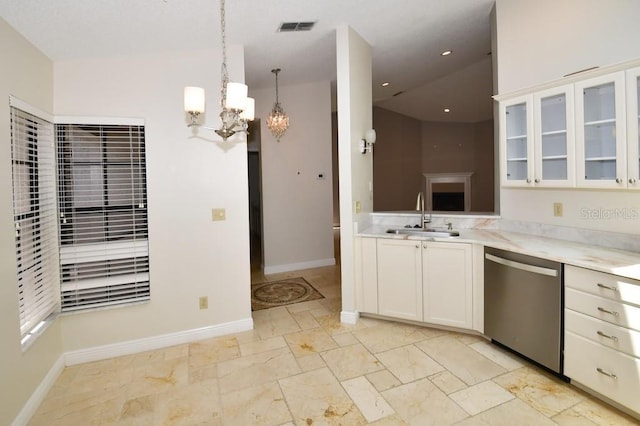 kitchen with light countertops, stainless steel dishwasher, a sink, visible vents, and a notable chandelier