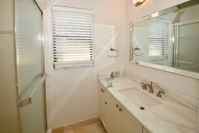 bathroom with a shower with shower door, tile patterned flooring, and vanity