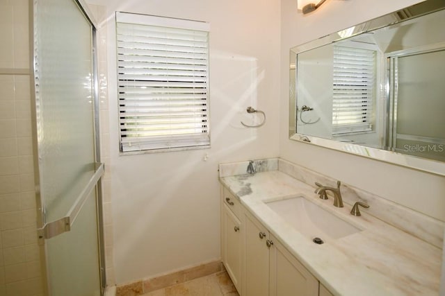 full bath with a stall shower, baseboards, and vanity