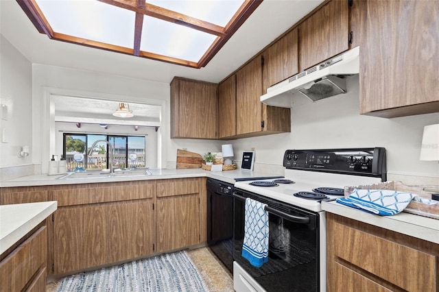 kitchen featuring under cabinet range hood, light countertops, a sink, and range with electric stovetop